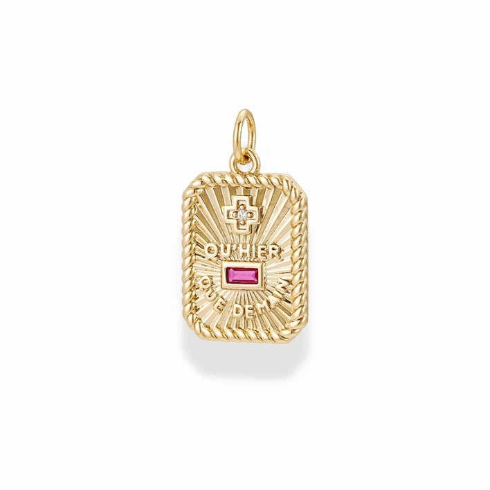a gold rectangular charm with text reading qu'hier que demain and a ruby accent on a white background