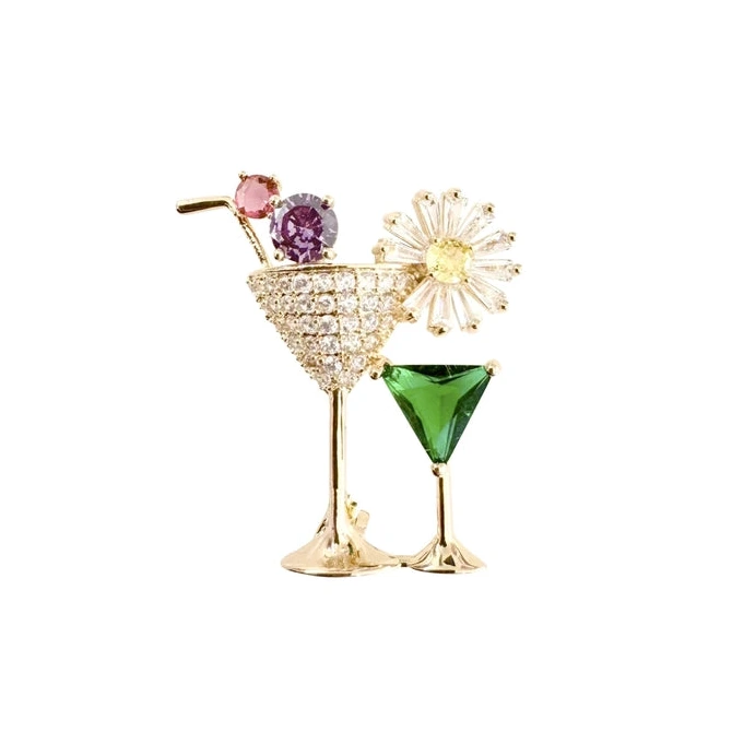 a multicolored brooch in the shape of a martini glass with a lemon garnish on a white background