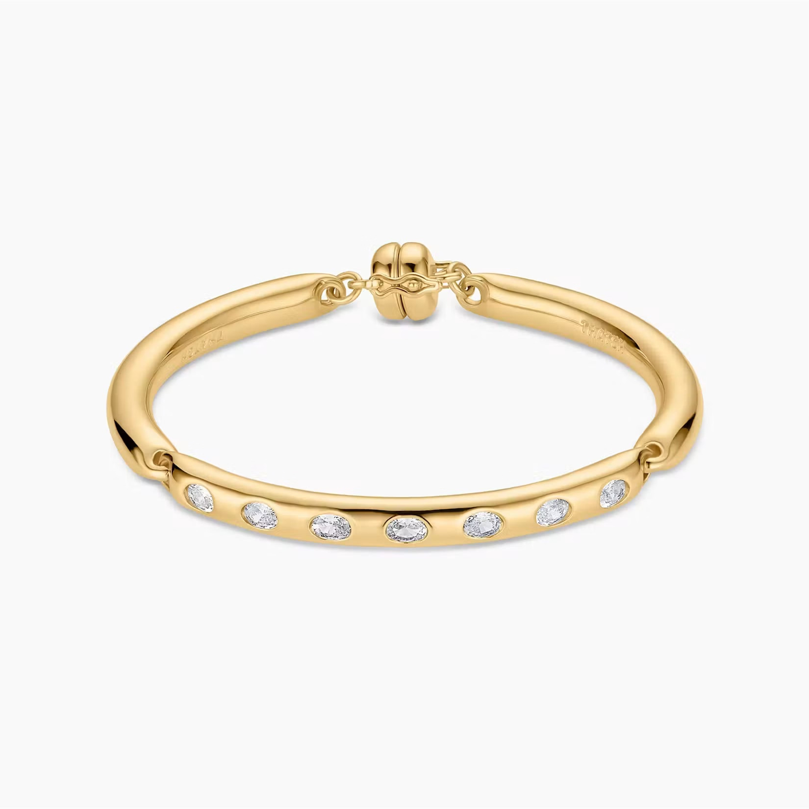 a gold bangle bracelet with inlay white stones and a bead shaped clasp over a white background