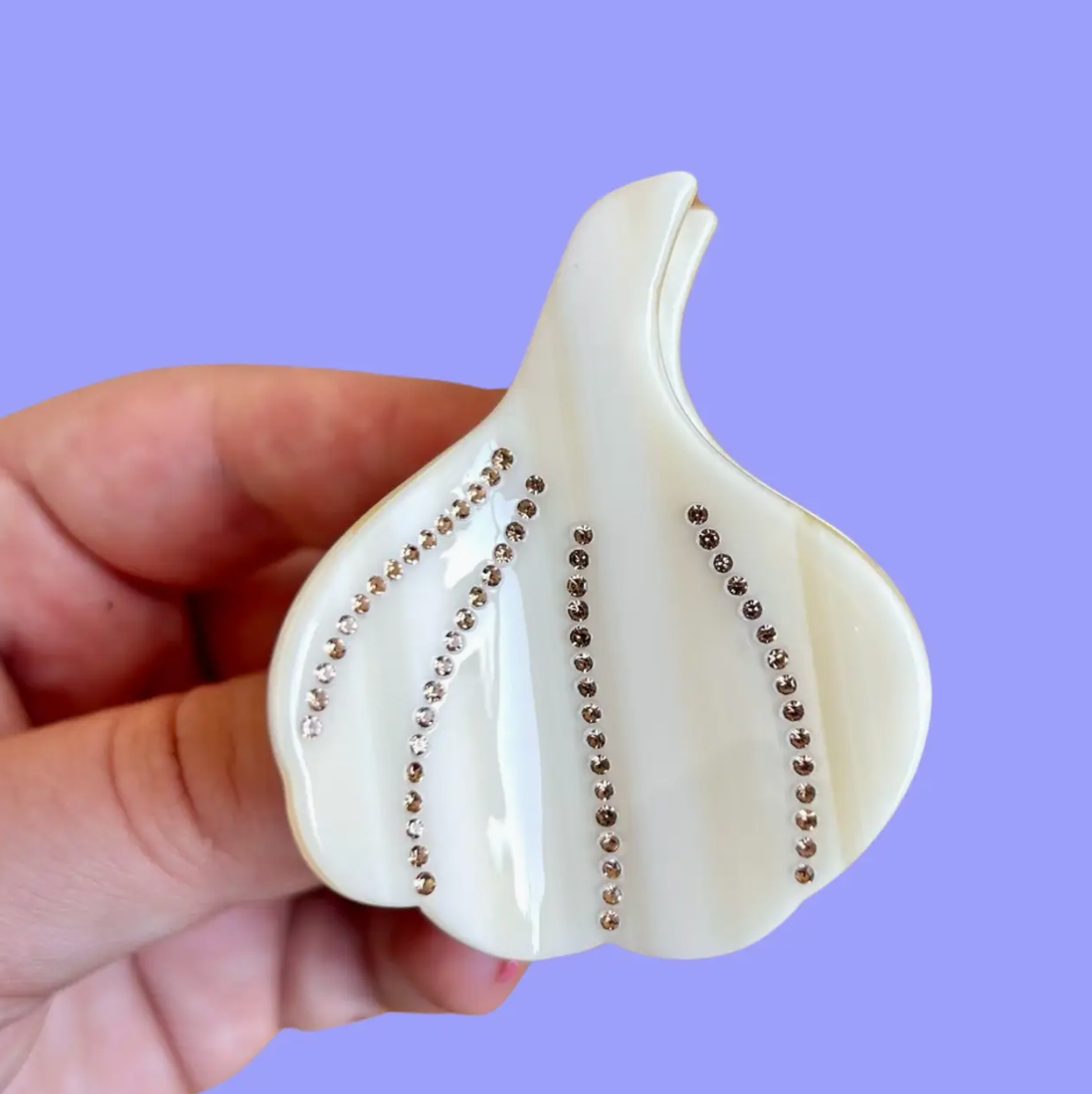 This garlic shaped hair claw has rhinestone details and is made of eco-friendly cellulose acetate.