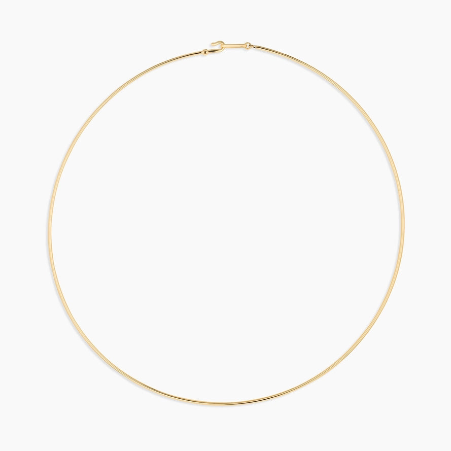 a gold wire choker necklace on a white background