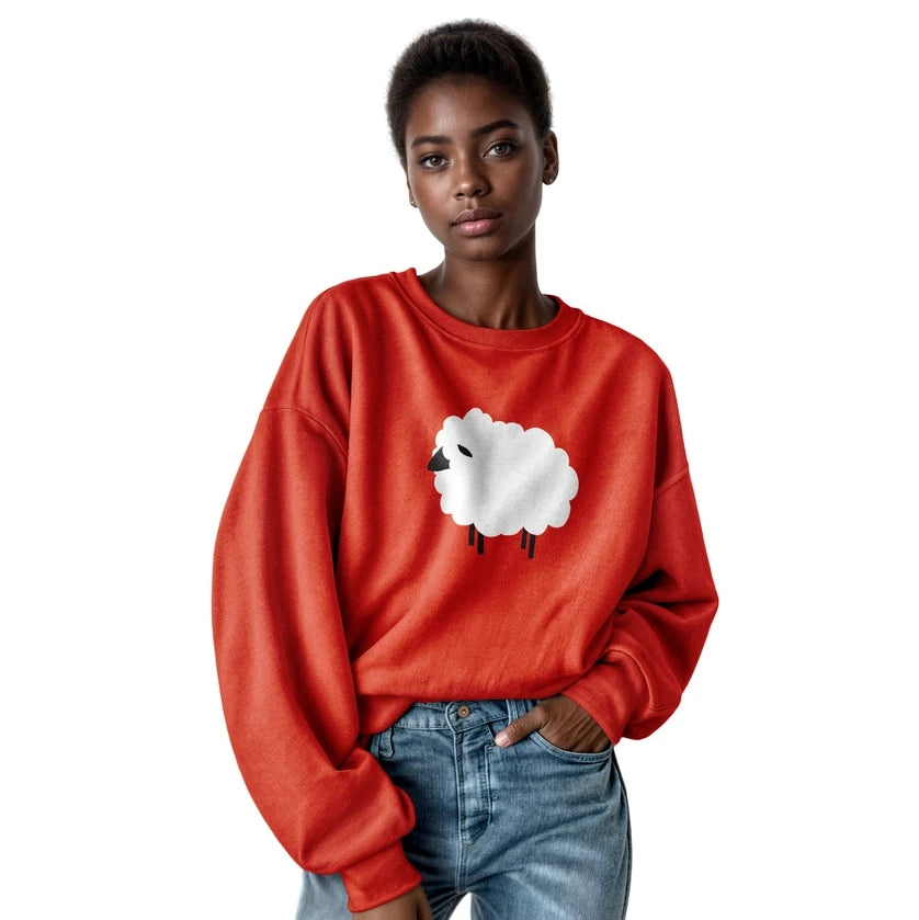 A model wearing a bright red crewneck sweatshirt with a white cartoon sheep graphic on the front, paired with blue jeans, against a solid white background.