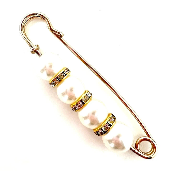 a gold pin with pearl and cz embellishments on a white background