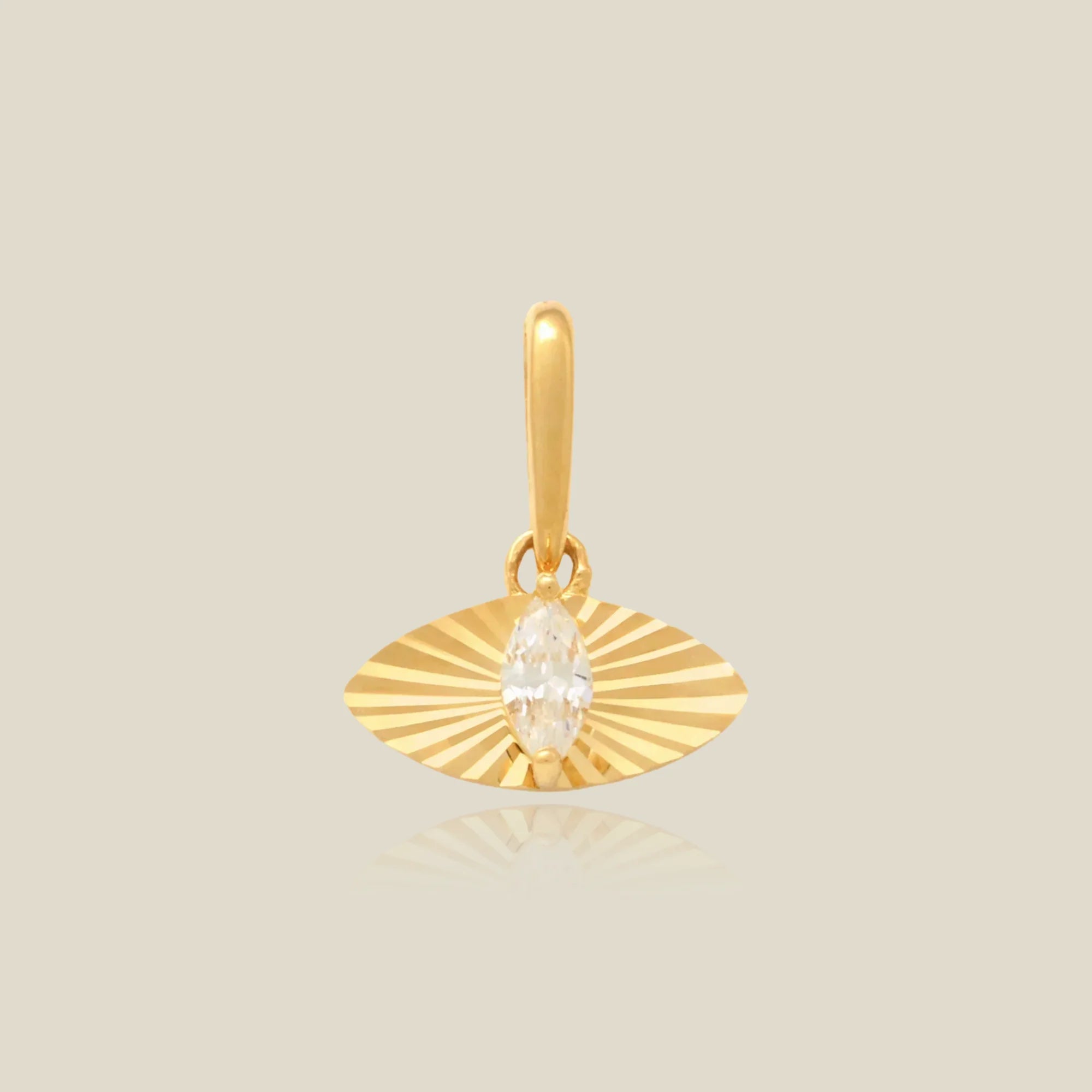 Gold pendant with a central gemstone on a beige background