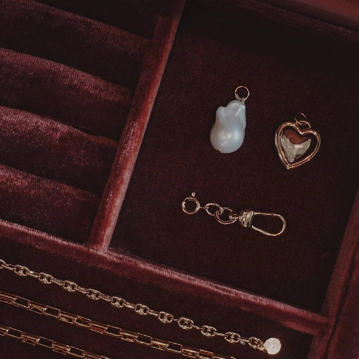 Jewelry set including necklaces and pendants on a red velvet surface