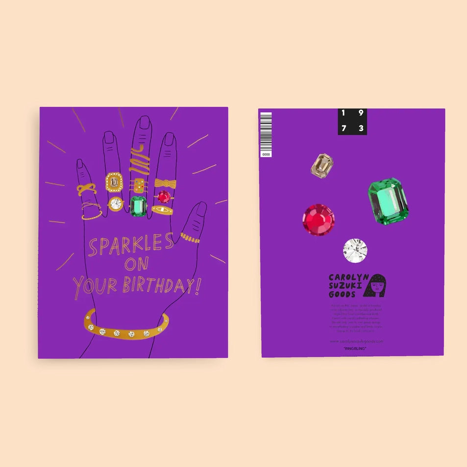 front and back of a greeting card with a purple background and an illustration of a hand wearing many gold rings overlaid with text reading sparkles on your birthday