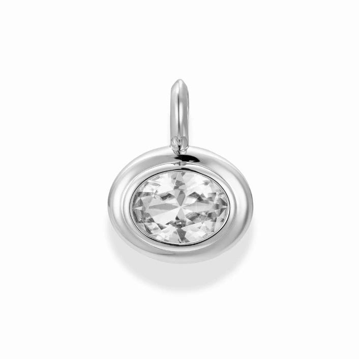 a silver charm with an oval shaped bezel set white sapphire on a white background