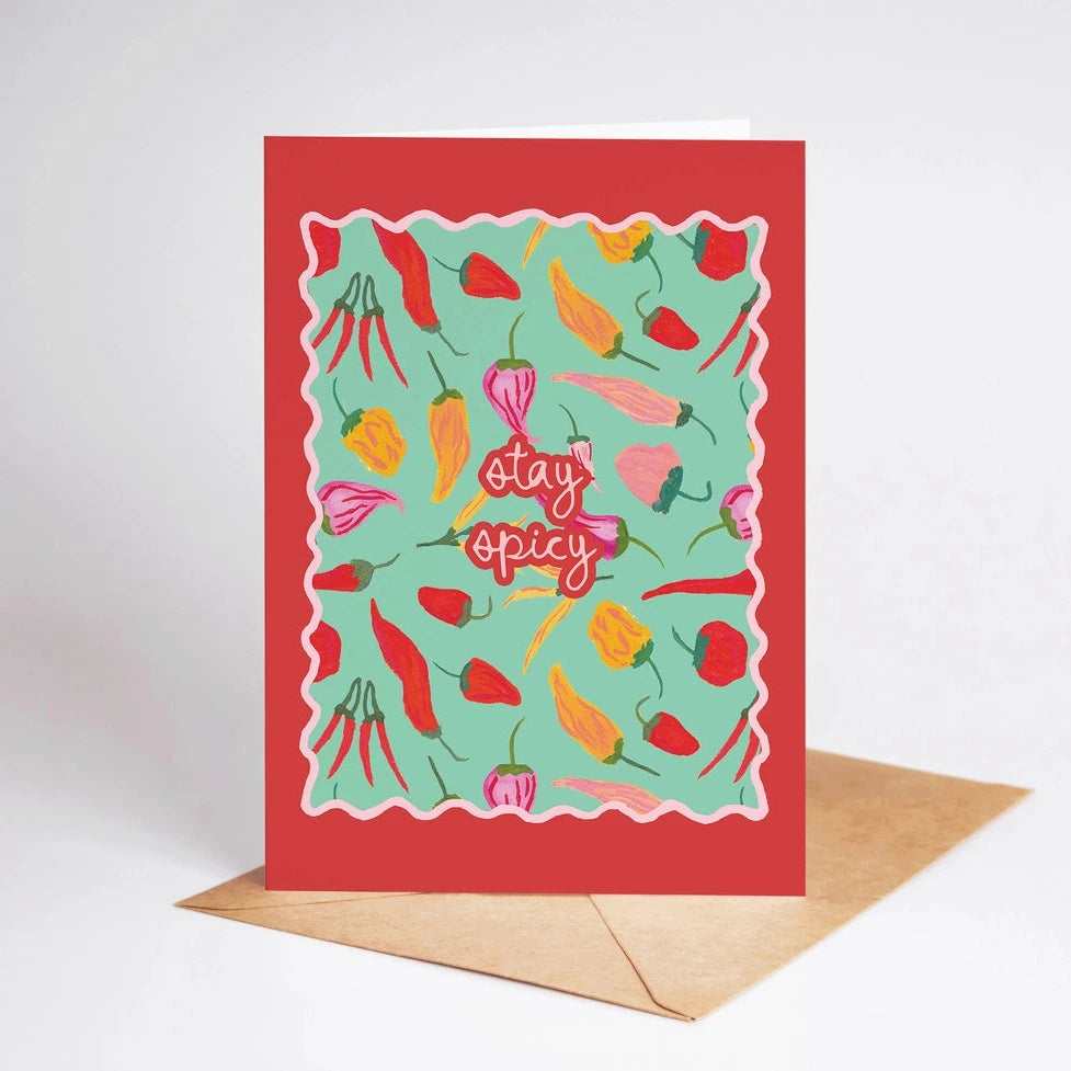Greeting card with colorful pepper illustrations and 'stay spicy' text on a red background, with a brown envelope.