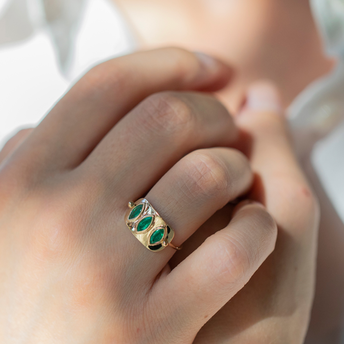 14K solid yellow gold ring with 1 × 1.7 cm gold plate and 0.60 ct triple marquise-cut emeralds — known as the Love Stone, symbolizing harmony, compassion, and unconditional love.