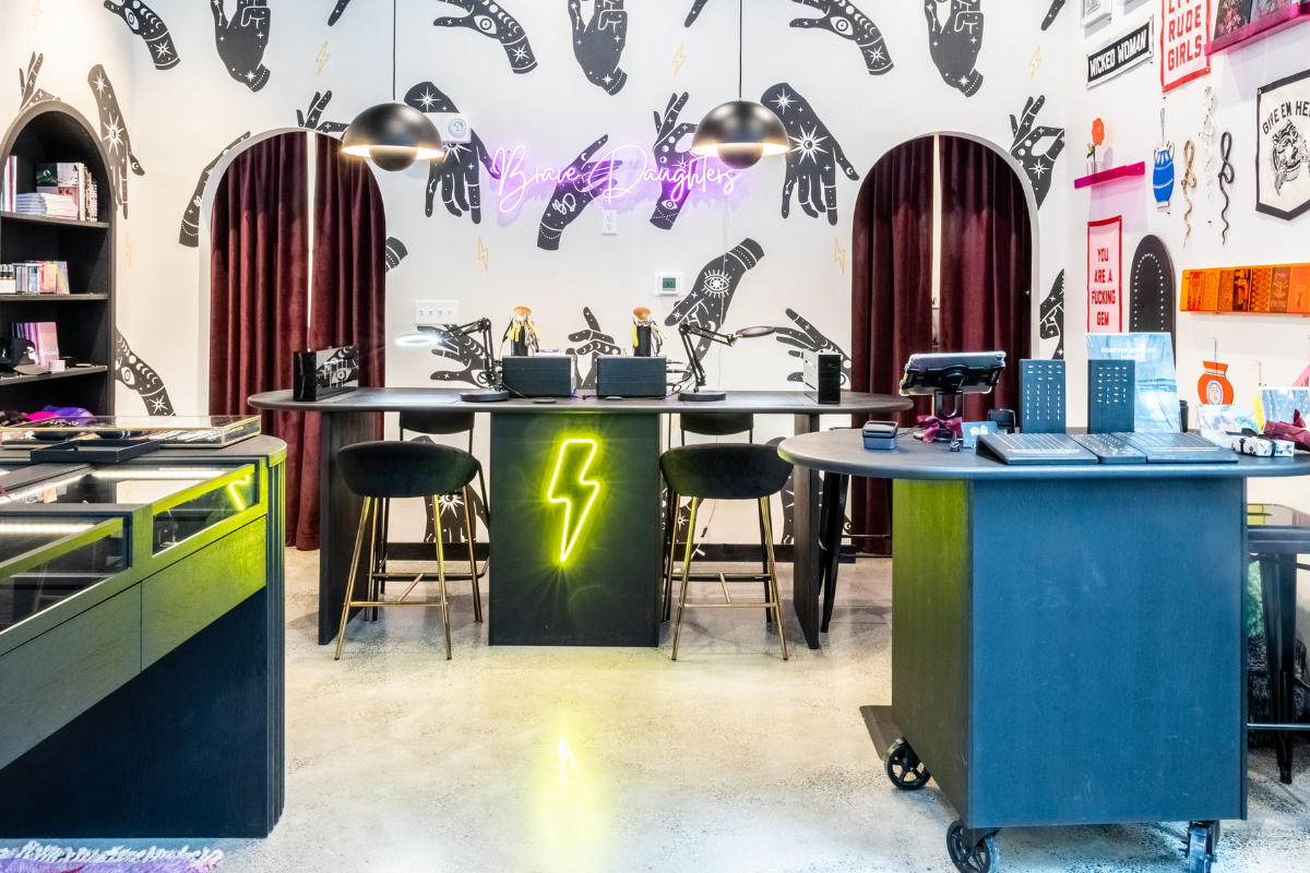 Brave Daughters Seaport Boston Forever Jewelry studio with neon lightning bolt sign and welding stations for permanent bracelets.