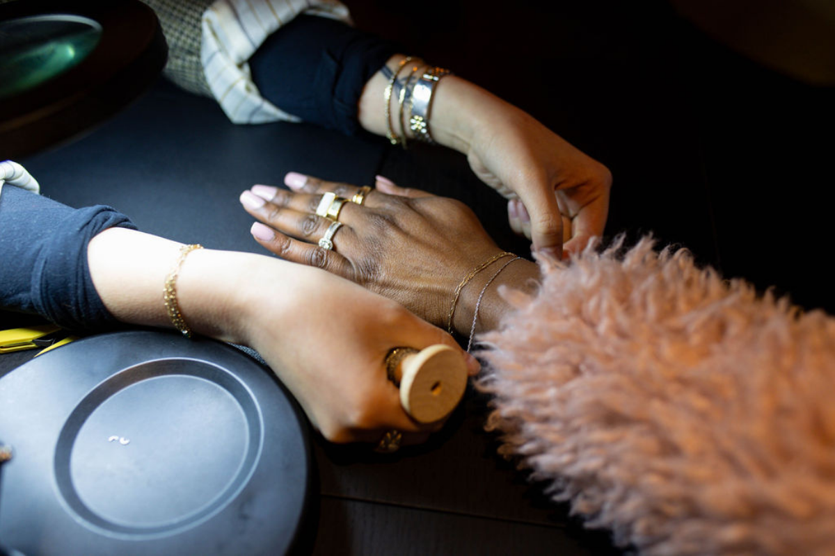 Brave Daughters jeweler welding a custom 14k gold permanent bracelet on a guest during a private jewelry event.