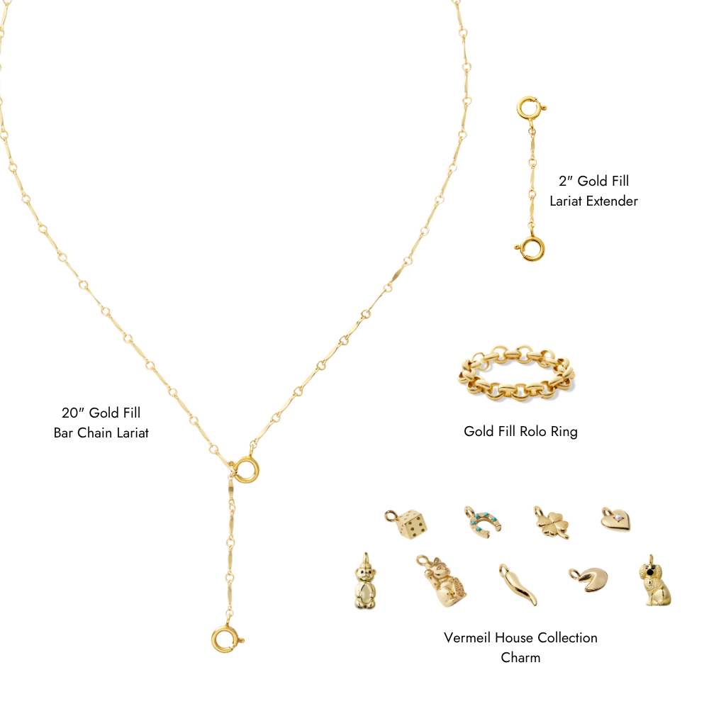 Gold jewelry set on a white background, including a 20" Gold Fill Bar Chain Lanet necklace, a 2" Gold Fill Lariat Extender, a Gold Fill Rolo Ring bracelet, and multiple Vermeil House Collection charms.