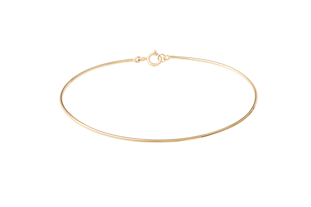 Gold bangle bracelet on a white background