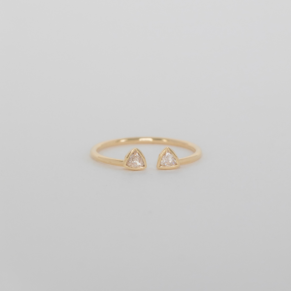 14k yellow gold open cuff ring with two diamond shaped cat ears on gray background