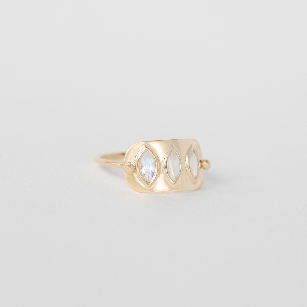 14k yellow gold triple marquise moonstone ring on a gray background