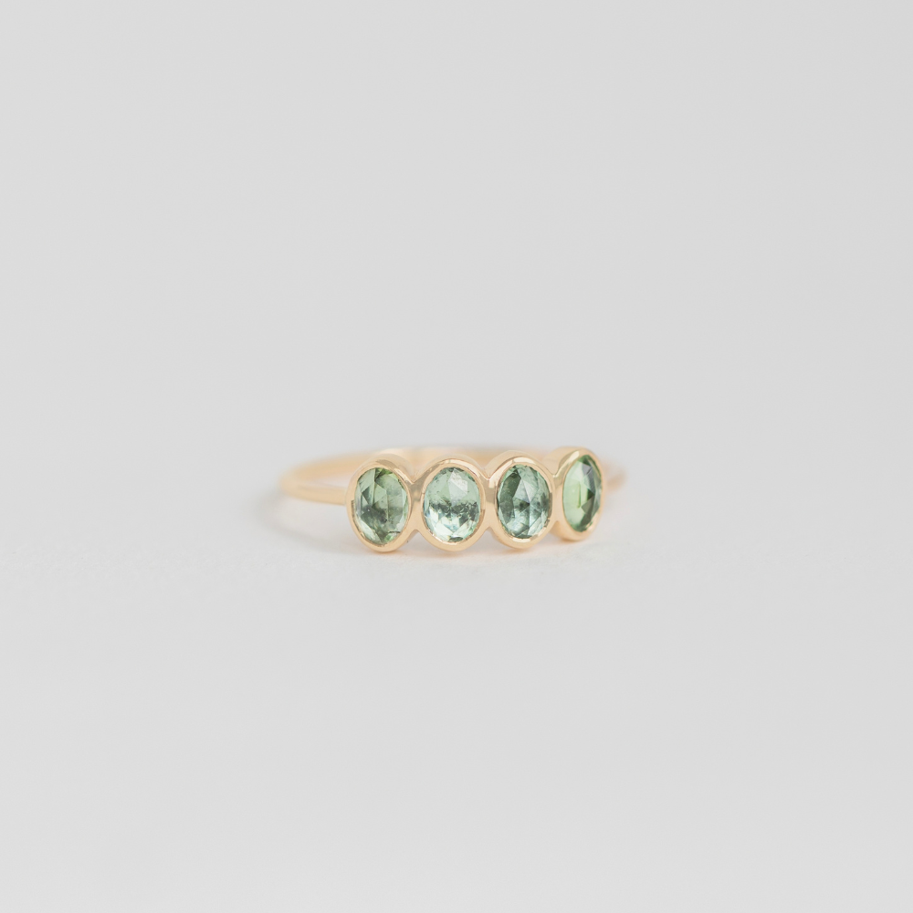 14k yellow gold tourmaline ring with 4 stones on gray backgorund