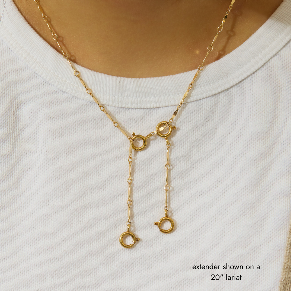 Gold necklace extender on a white shirt with text indicating length