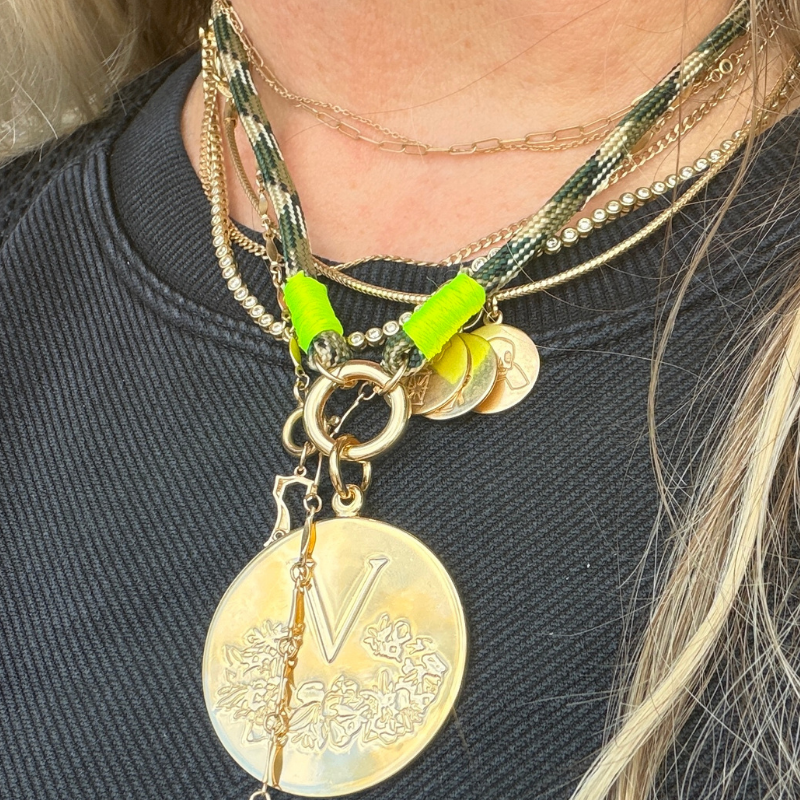 Necklace with gold coins and green accents on a dark background