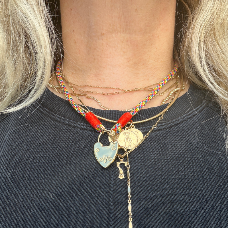 Necklace with colorful beads and charms worn by a person with blonde hair.