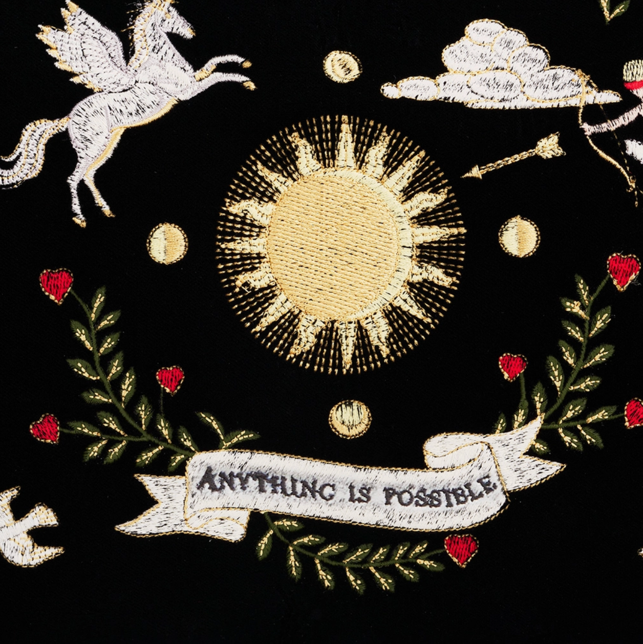 Embroidered design with sun, moon, stars, and 'Anything is Possible' banner on a black background.
