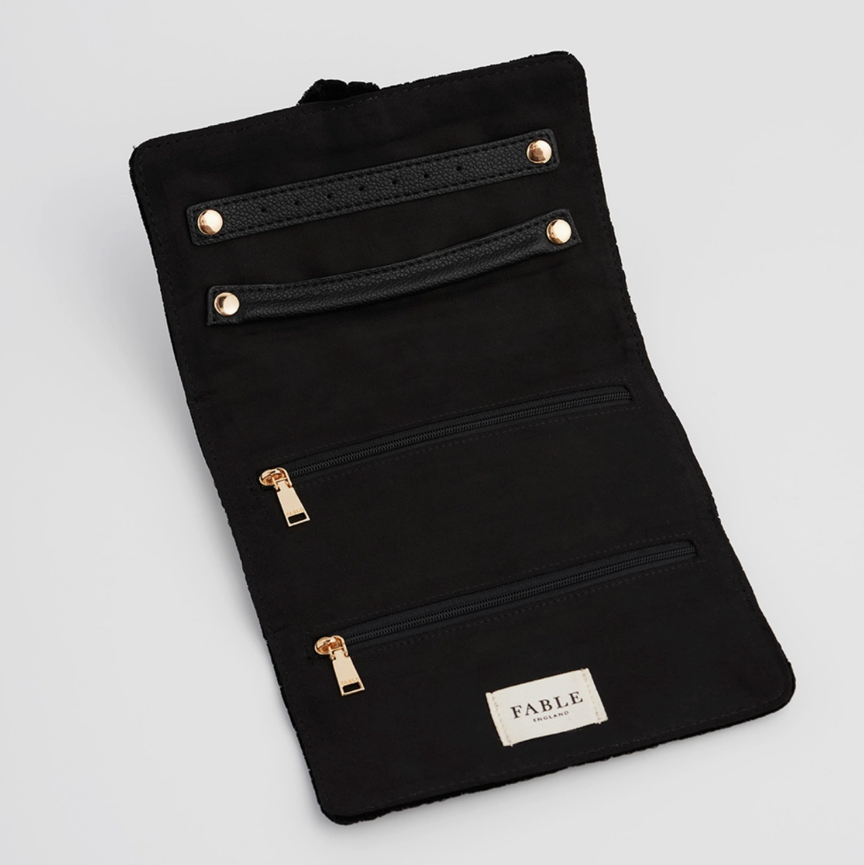 quilted velvet jewelry roll open with embroidered motifs on white background