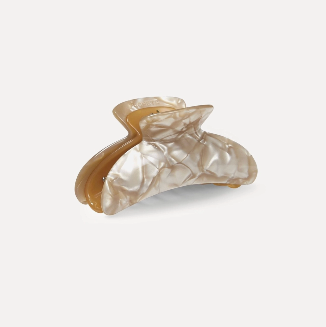 Shell-like hair clip on a light gray background